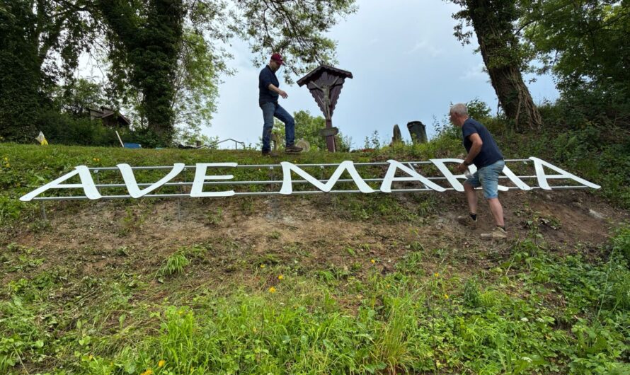 Vrijwilligers plaatsen nieuwe letters AVE MARIA bij de Mariagrot aan de Loorberg